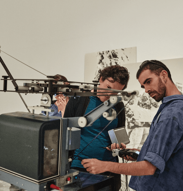 Dos chicos observan una máquina en una de las salas del museo